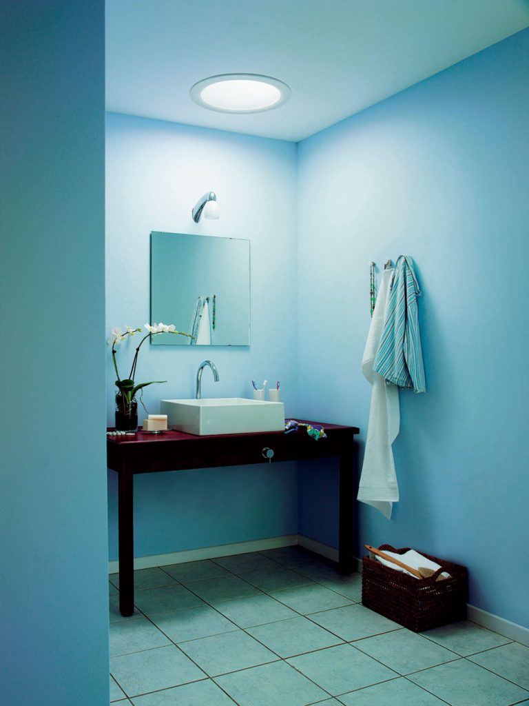 Názorná ukážka toho, čo dokáže denné svetlo privedené svetlovodom. Vľavo kúpeľňa s umelým osvetlením nad zrkadlom. Vpravo rovnaká miestnosť vybavená svetlovodom.