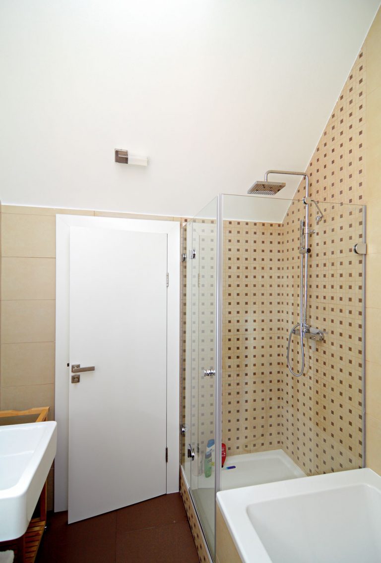 V kúpeľni si na svoje prídu milovníci pohodovej vane, ale aj rýchlej sprchy. Zaujal nás detail napojenia štvorčekovaného obkladu na šikminu podstrešia: dali si tu záležať.