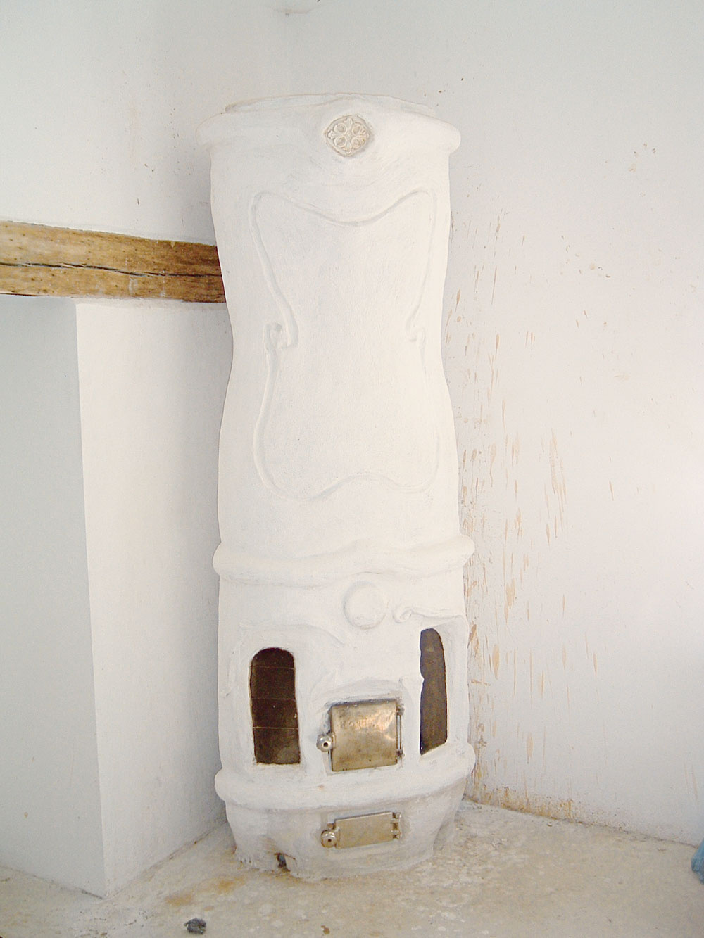 Omietaná pseudobaroková pec bola realizovaná na workshope v Brne v roku 2006. Ako základ sa použil princíp pece s tromi zvislými a jedným vodorovným ťahom. Tento typ bol rozšírený v strednej Európe. Používal sa najmä v mestských bytoch a meštianskych domoch. Nazývame ju aj izbová pec. Proporčne je na malom základe vysoké teleso. Ohnisko je zásobované vzduchom kanálikmi okolo skiel (1) a prídavným vzduchom vo dvoch rovinách (2 a 3). Prívod vzduchu roštom (4) je minimálny. Z ohniska spaliny odchádzajú vodorovným ťahom (5) do čelného zvislého ťahu (6). Potom klesajú – padajú stredom pece (7), obracajú sa a idú do komína stúpajúcim ťahom (8). Pec má aj dymovú medzierku. Stredom pece vedie plechová rúra (10) obalená v pletive a zaliata hlinou. V nej sa ohrieval vzduch nasávaný v spodnej (11) a vyfukovaný v hornej (12) časti pece. Hlinený zálev pôsobil teploakumulačne a chránil rúru pred prehorením. Hlinená omietka bola uchytená na kovovom pletive, mala niekoľko vrstiev, posledná vrstva bola