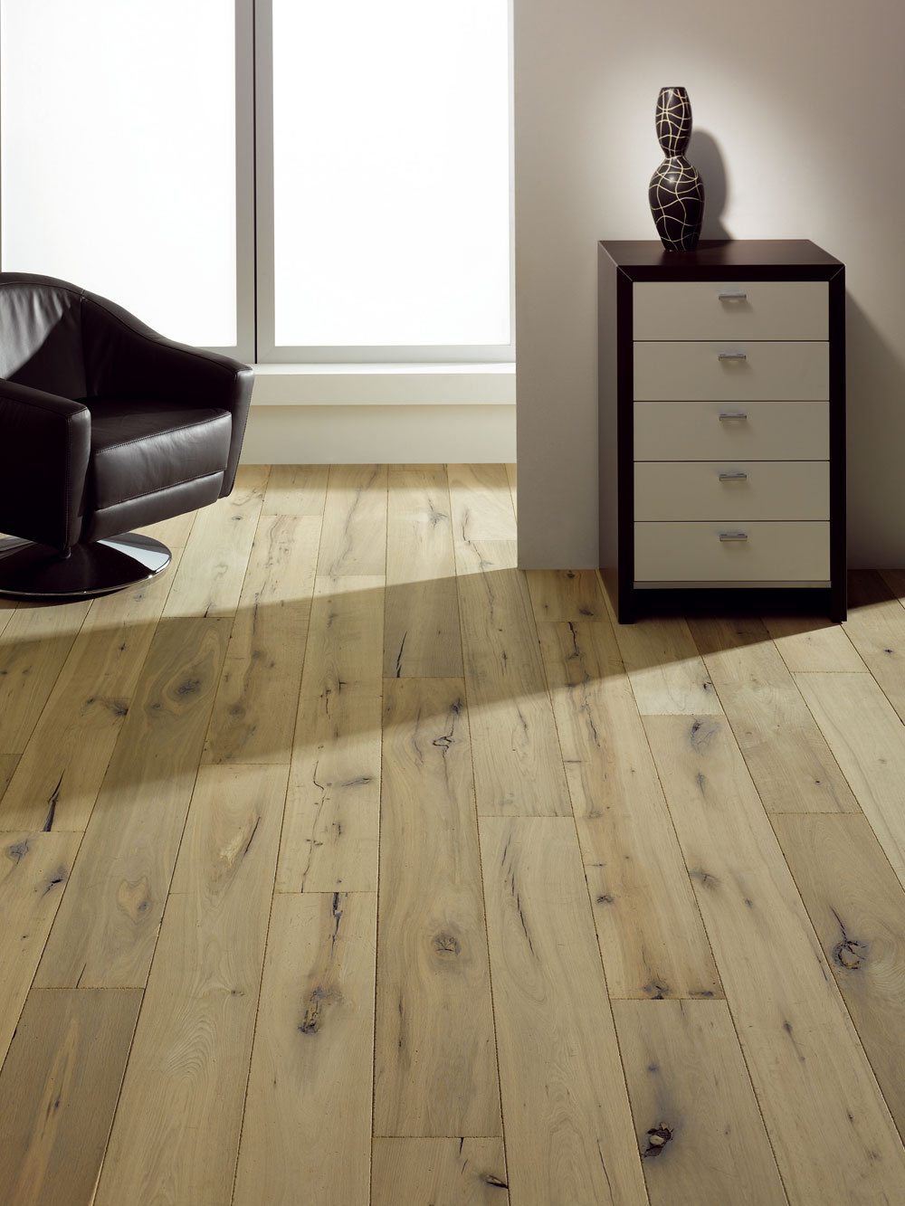 Táto exkluzívna podlahová krytina z bieleného a kefovaného duba s tmavými sukami dokazuje, že povrchová úprava dokáže zázraky aj s európskym drevom (foto: Empiri Wood Design)