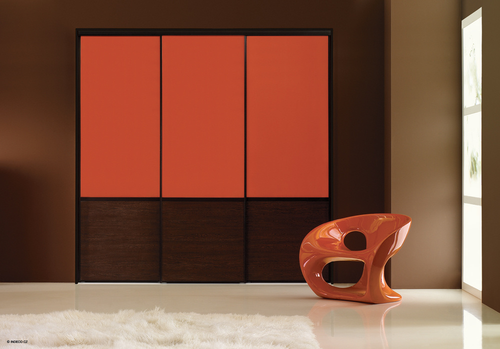 Použitím sýtych farieb sa dá docieliť oživenie priestoru a aktivácia emócii. Interiér s použitím výrazné červeného lacobelu na posuvných dverách skrine pôsobí aktivizujúco, dynamicky a moderne. Na vyváženie atmosféry a čiastočné zastabilizovanie výraznej červenej farby bola citlivo použitá uzemňujúca hnedá farba v spodnej časti skrine.