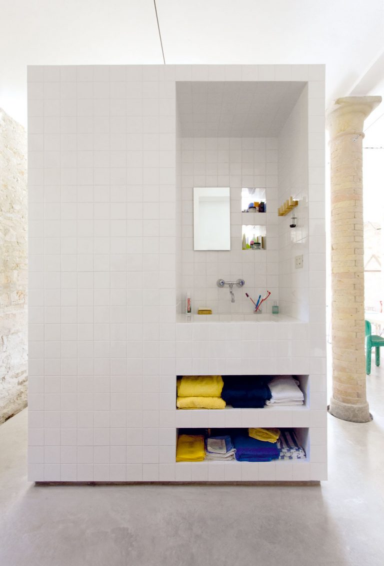 Kúpeľňu tvorí len masívny biely blok, voľne stojaci na betónovej podlahe.