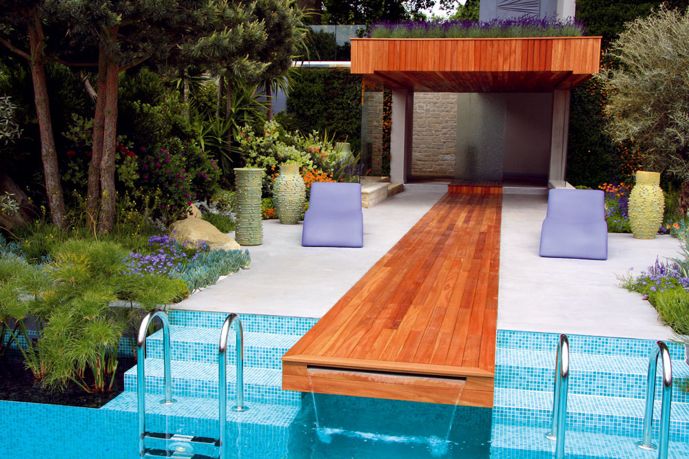 Betónovú terasu s dreveným kobercom spestrujú plastové ležadlá a umelecké vázy od Davida Shilinga. O strapatosť strechy sa postarala výsadba levandúľ. 