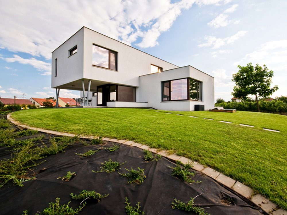 Moderný dom stojí na miernom svahu s výhľadom na okolitú krajinu.