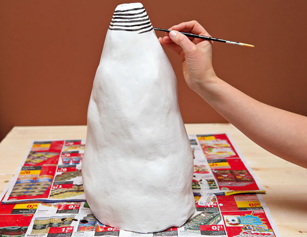 8. Suchú vázu zbavte prachu pomocou malej kefky alebo handričky a širokým štetcom natrite neriedenou bielou farbou (ak treba, aj v dvoch vrstvách). Na zaschnutý podklad namaľujte tenkým štetcom čierne pásiky, prípadne iný vzor (fantázii sa medze nekladú).