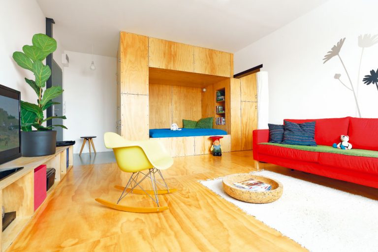 Použitie borovicovej preglejky na „Skrini“, podlahe aj na nízkej polici celý priestor izby zjednotilo. Dizajnové kúsky nábytku mu dodávajú dynamiku.