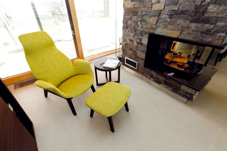 Rozľahlý interiér člení okrem nábytku aj kozub, ktorý vymedzuje miestečko na relaxačný kútik. Väčšina nábytku (vrátane kresielka s podnožkou a kruhového stolíka) tu je od značky Poliform.