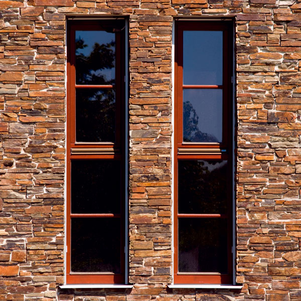 Kamenná primurovka napodobňuje murivo prítomné v okolí. Pri návrhu úzkych okien sa architektka inšpirovala vetracími otvormi, ktoré sa používali na stodolách.