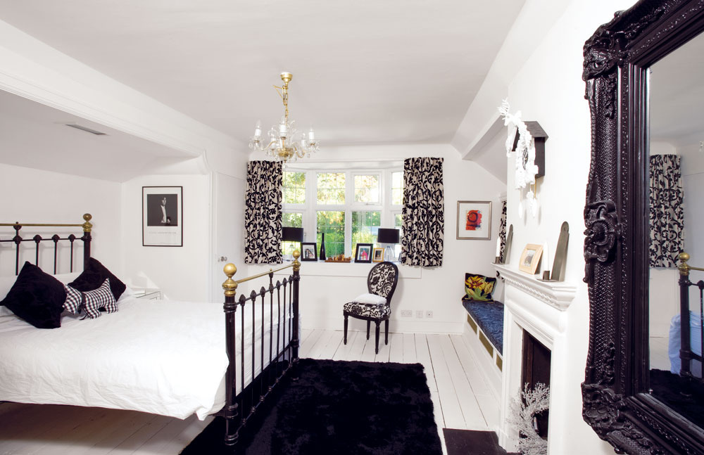 Rokoková spálňa je zariadená rozličnými čiernymi a bielymi kusmi nábytku. Doplnky vrátane bielych kukučkových hodín nad kozubom ctia rovnaký štýl aj farebnosť.