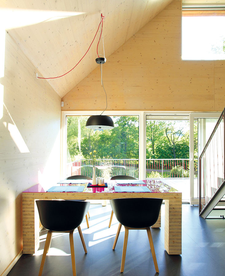 Interiér drevodomu z veľkoformátových CLT panelov NOVATOP. Z rovnakých panelov, ako je dom samotný, navrhli architekti aj jedálenský stôl. 