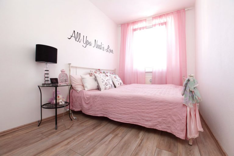 Ružová sa stala síce dominantou, ale v spálni jej dodáva dramatickosť čierny nápis na stene a čierna farba na stolovej lampe.