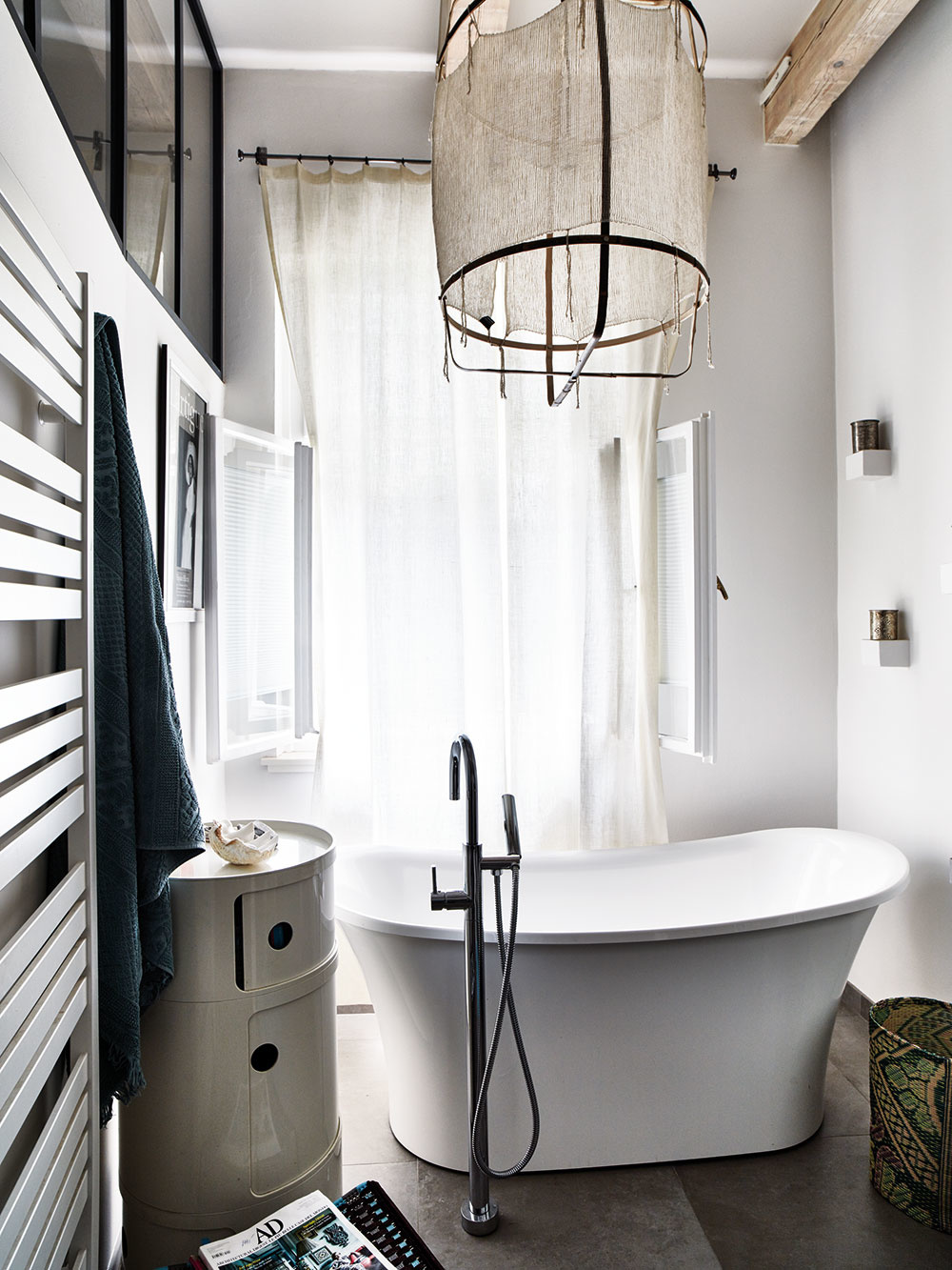 Kúpeľňa s výhľadom do záhrady predstavuje jedno z Monikiných najobľúbenejších miest. „Kombinácia minimalistickej farebnosti, mramorovej mozaiky, orientálneho zrkadla a lustra od Ay illuminate je pre mňa veľmi príjemná. Manželova kúpeľňa je, naopak, veľmi pánska a úsporná,“ približuje.  