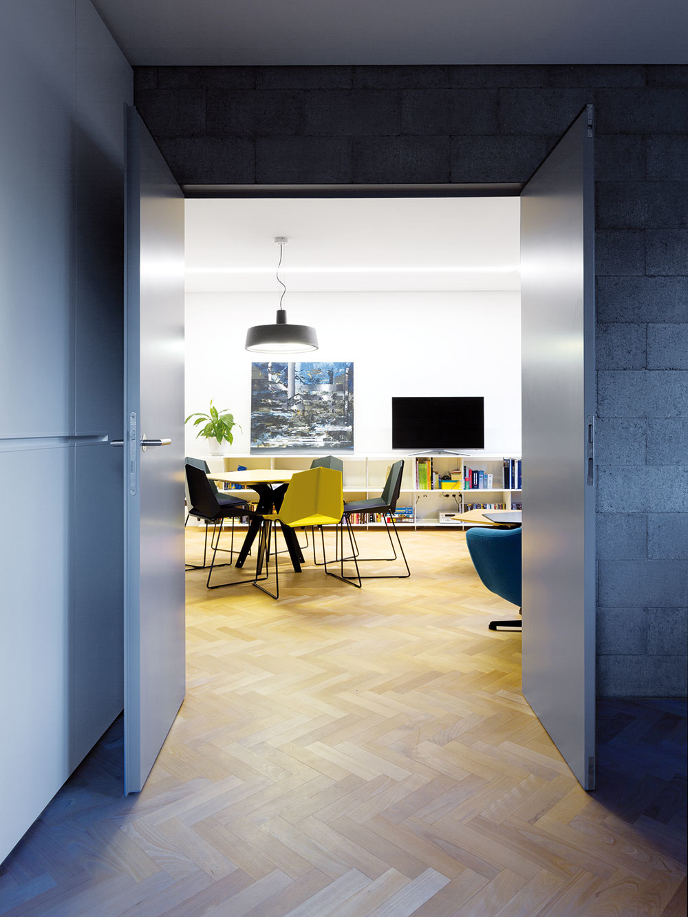 Moderné kontrasty. Tvrdosť betónu a ocele zjemňuje drevená podlaha, osvetlenie a závesy. Spoločne dotvárajú príjemný pocit otvorenosti a jednoduchosti. 