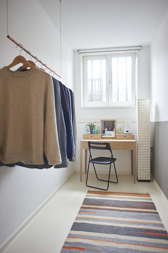 Úzka izba slúži zatiaľ ako šatník, do ktorého si majiteľ vymyslel minimalistický vešiak na oblečenie.
