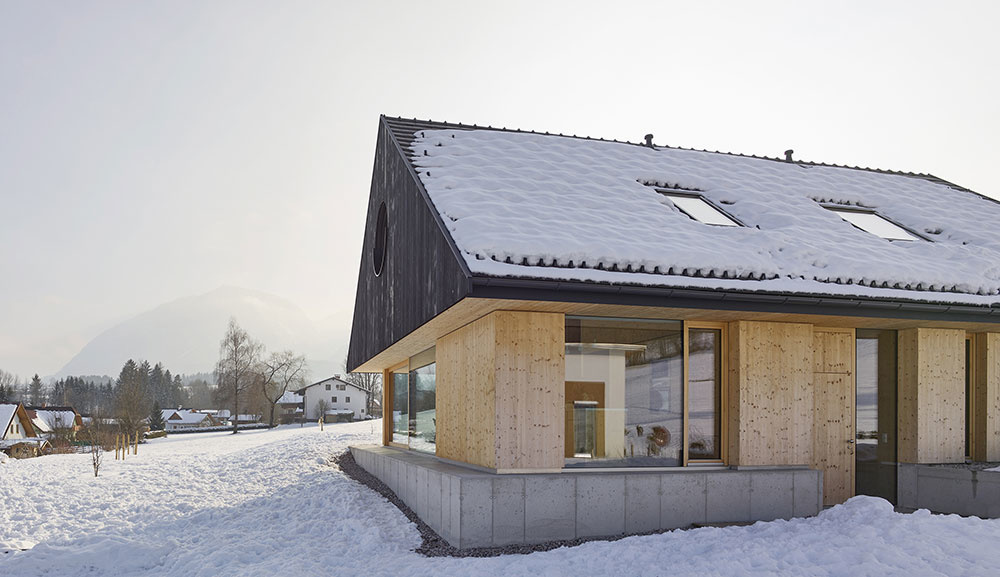 Rodinný dom postavený z troch materiálov: drevo, betón a sklo
