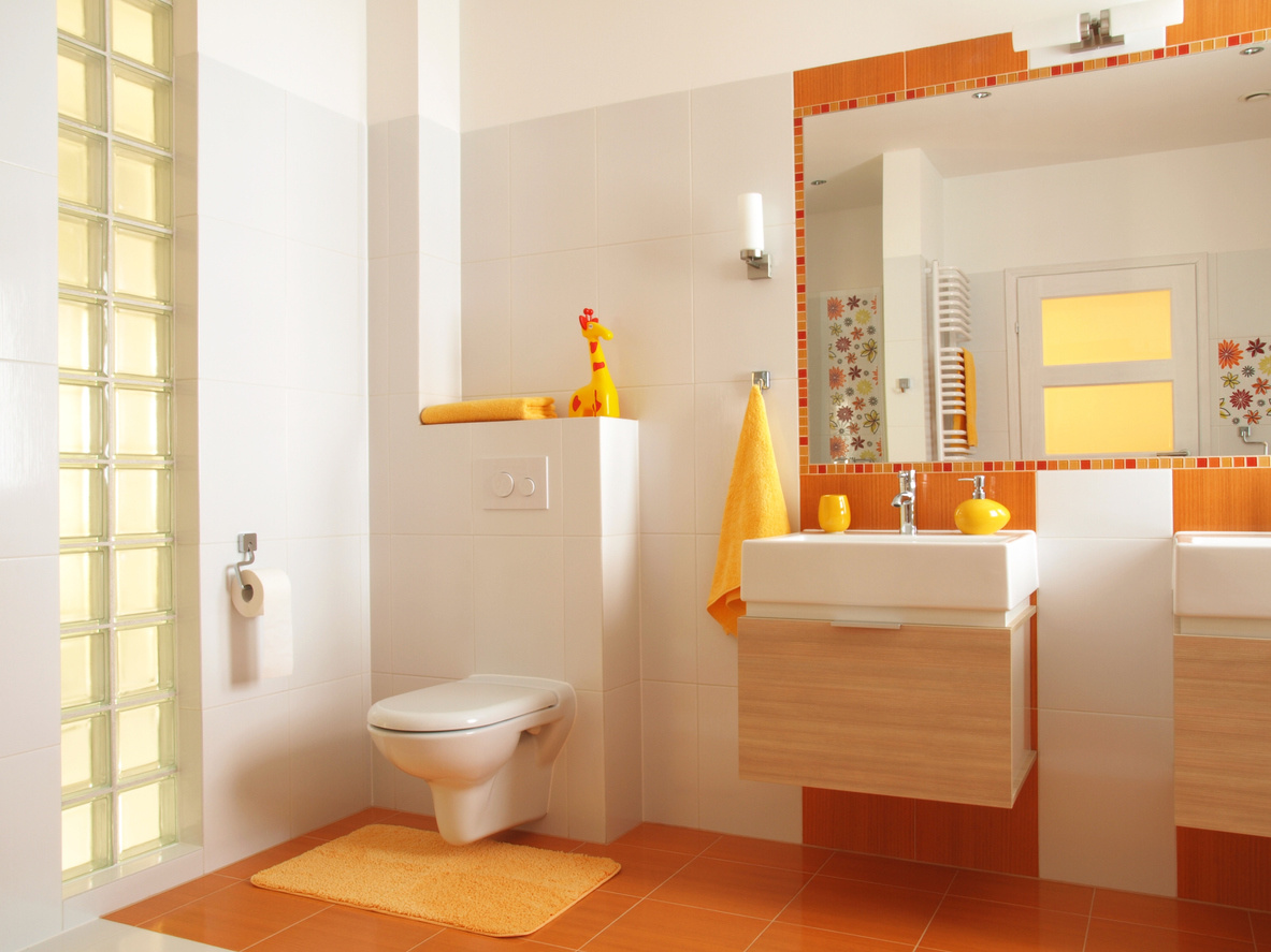 Friendly bathroom for children with orange tiles and flower decors,