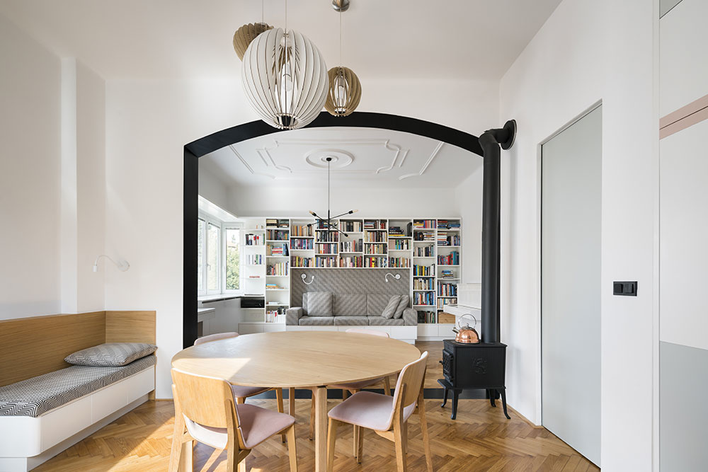 Čierny portál zároveň zvýrazňuje prepojenie najdôležitejších spoločenských častí bytu – kuchyne s jedálenským stolom a obývačky, ktorú architekti radi označujú ako salónik.