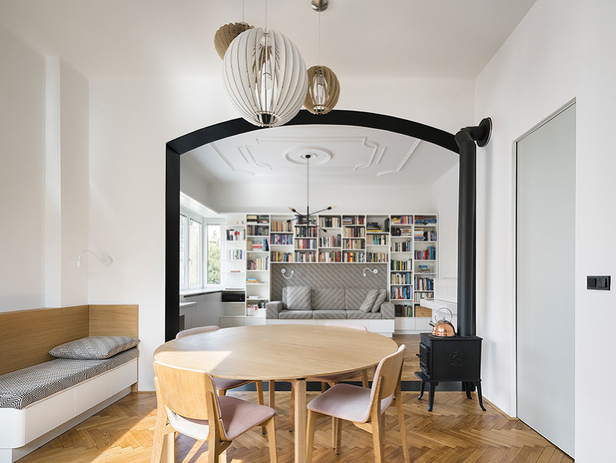 Čierny portál zároveň zvýrazňuje prepojenie najdôležitejších spoločenských častí bytu – kuchyne s jedálenským stolom a obývačky, ktorú architekti radi označujú ako salónik.