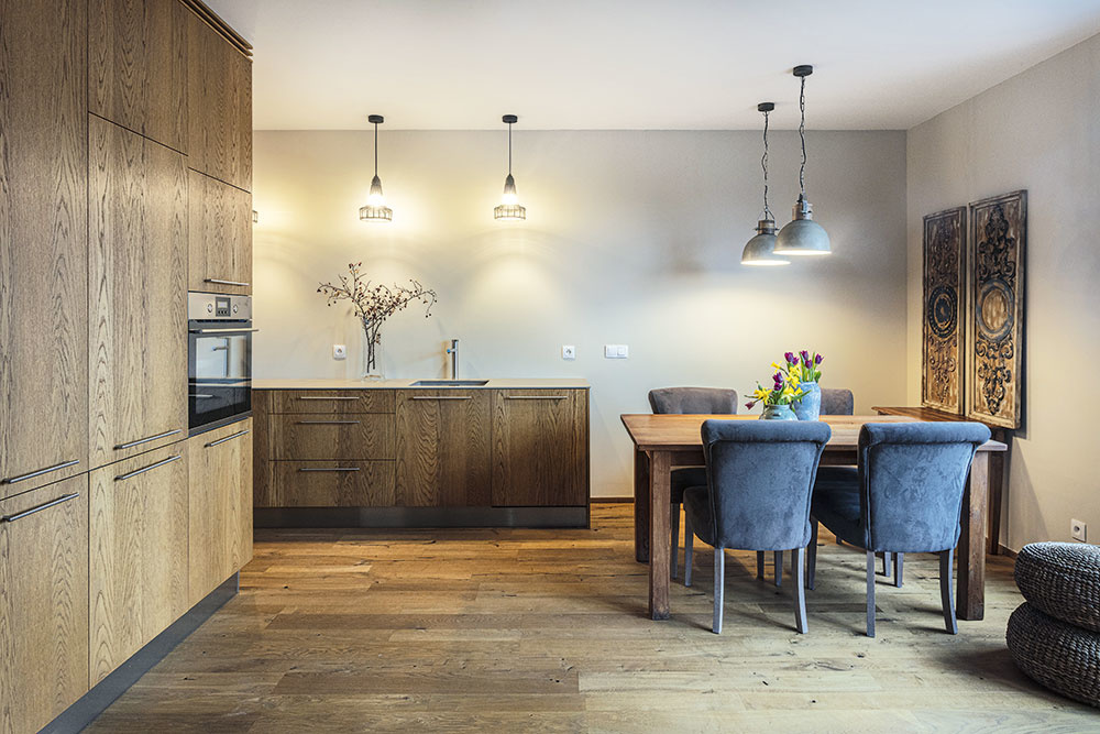 Kuchyňa a jedáleň sú prepojené s obývacou izbou a kuchynská linka je riešená tak, aby bola čo najmenej rušivou súčasťou priestoru a zároveň sa do nej vošlo všetko potrebné. Spájajúcim prvkom je aj dubová podlaha a farebné ladenie interiéru.