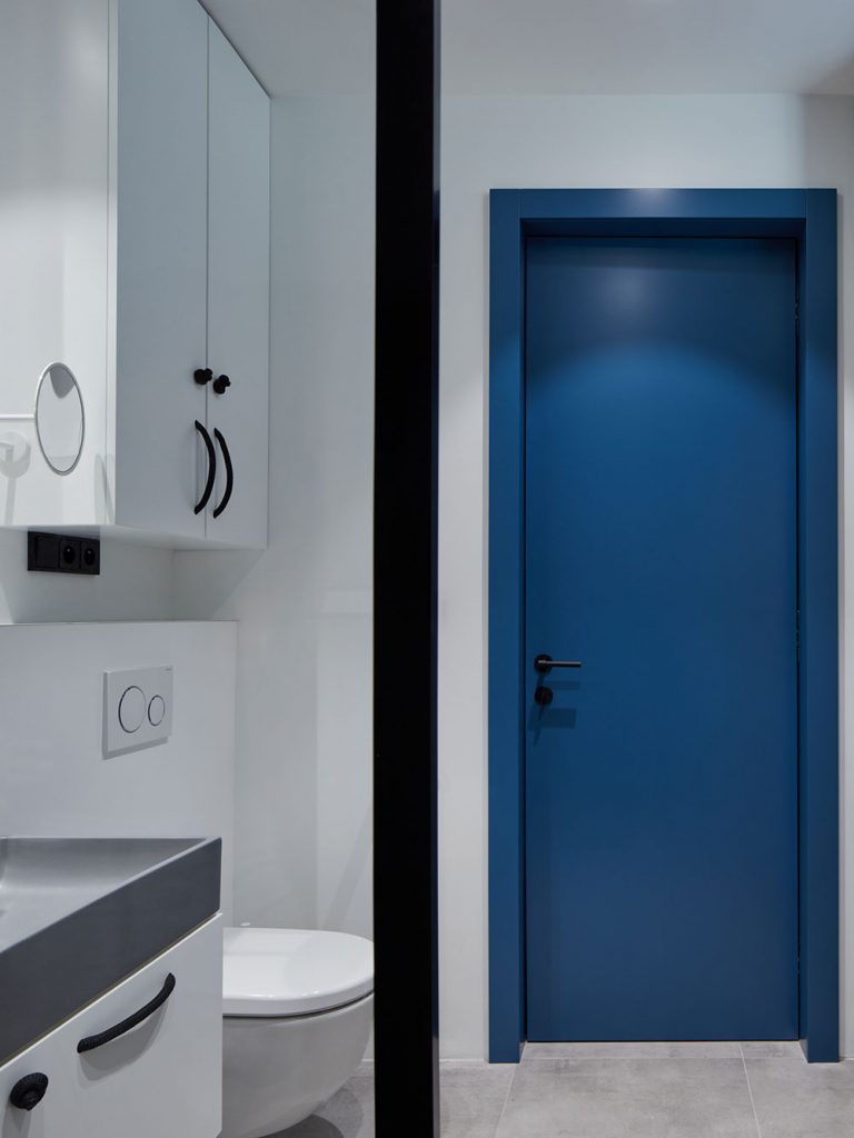modré sú tiež dvere v inak farebne monotónnej kúpeľni