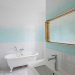 kúpeľňa, ktorá okrem bielych obkladačiek má tieňovanú bielo-modrú maľovku