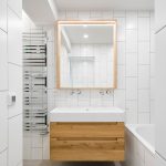 kúpeľňa so bielym obkladom a drevenými prvkami