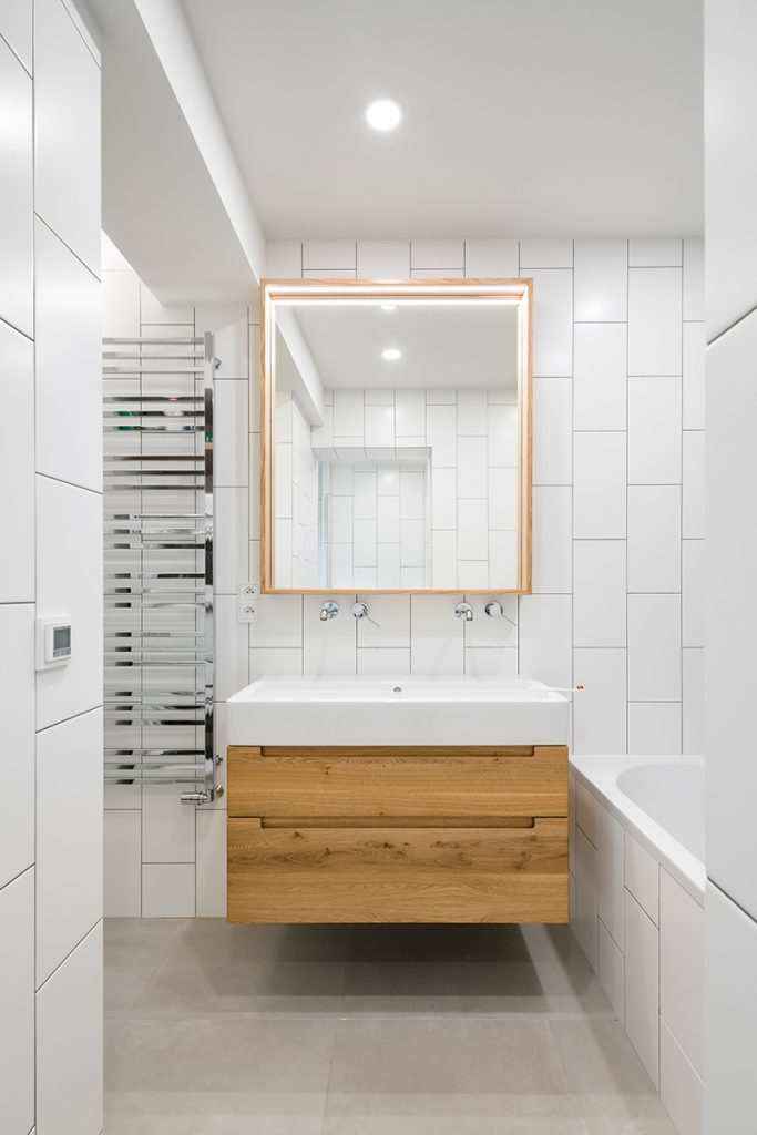 kúpeľňa so bielym obkladom a drevenými prvkami