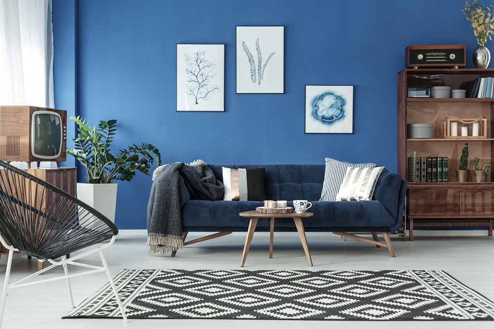 modrá obývacia izba so sedačkou a starou komodou