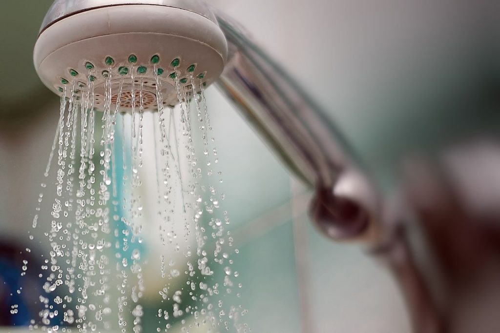 teplá voda preteká cez sprchovaciu hlavicu