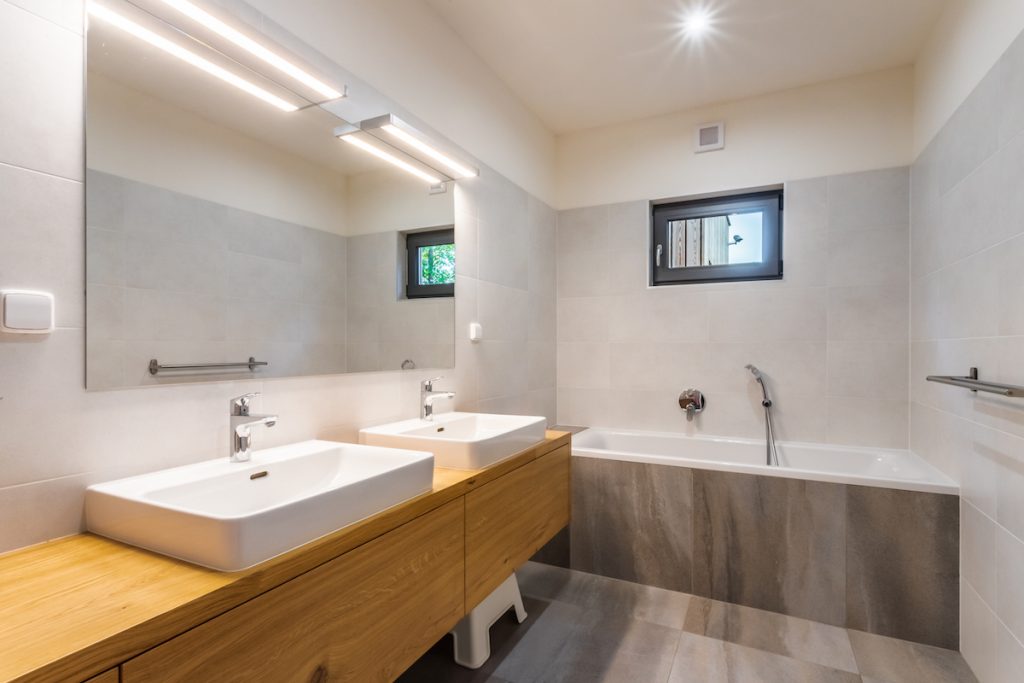 V kúpeľni vyniká kombinácia veľkoformátových dlaždíc, ktoré sú imitáciou mramoru a dreva.