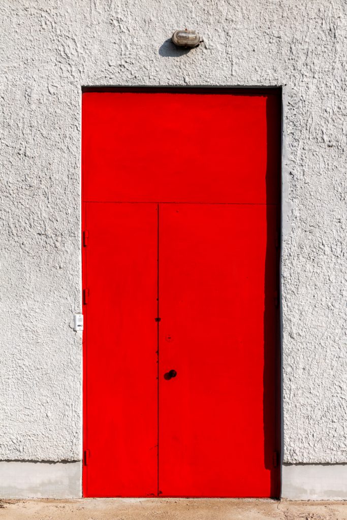 Červené dvere v betónovej stene