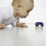 Dieťa hrajúce sa na zemi s hračkou