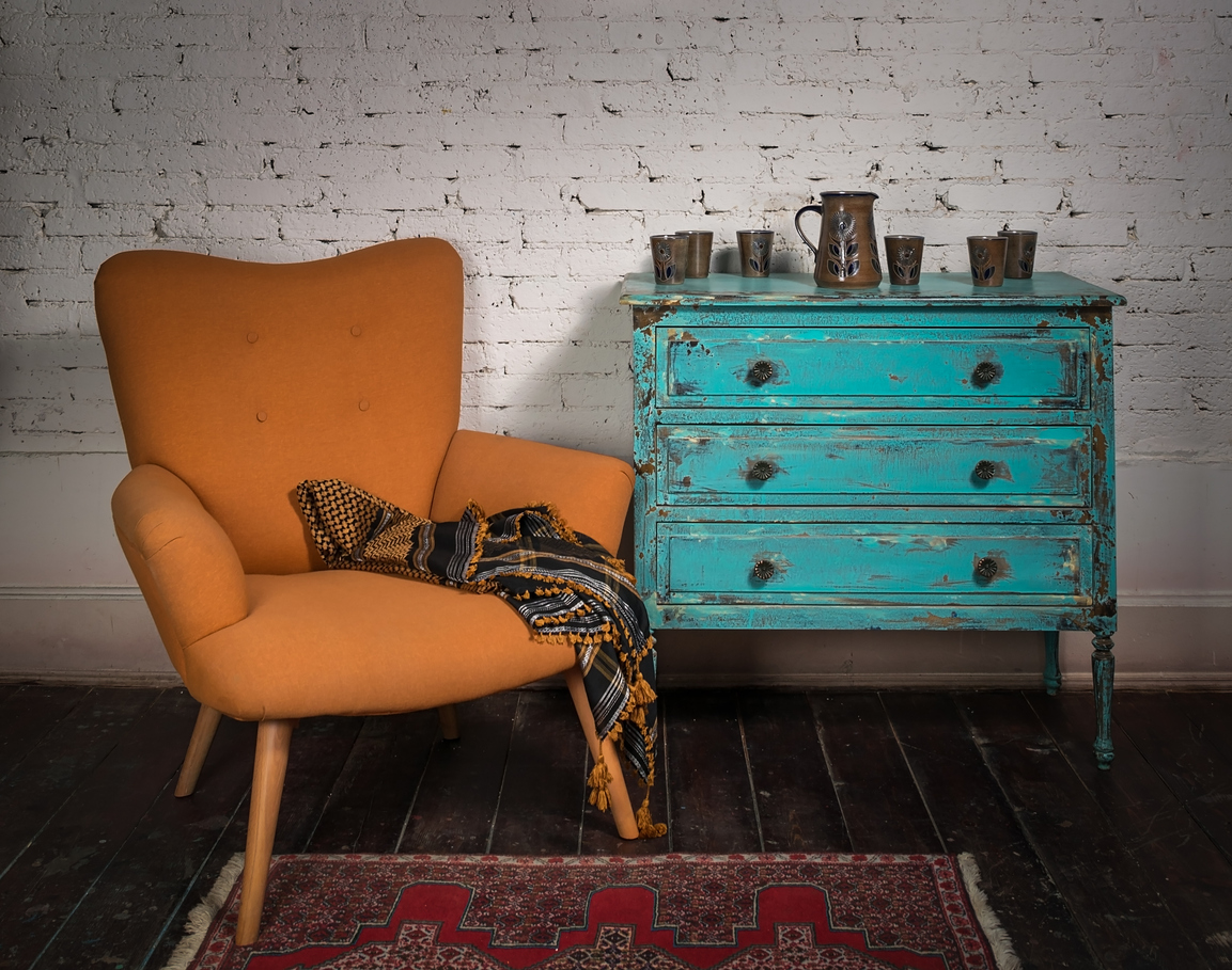Vintage orange armchair, blue cabinet and ornate scarf