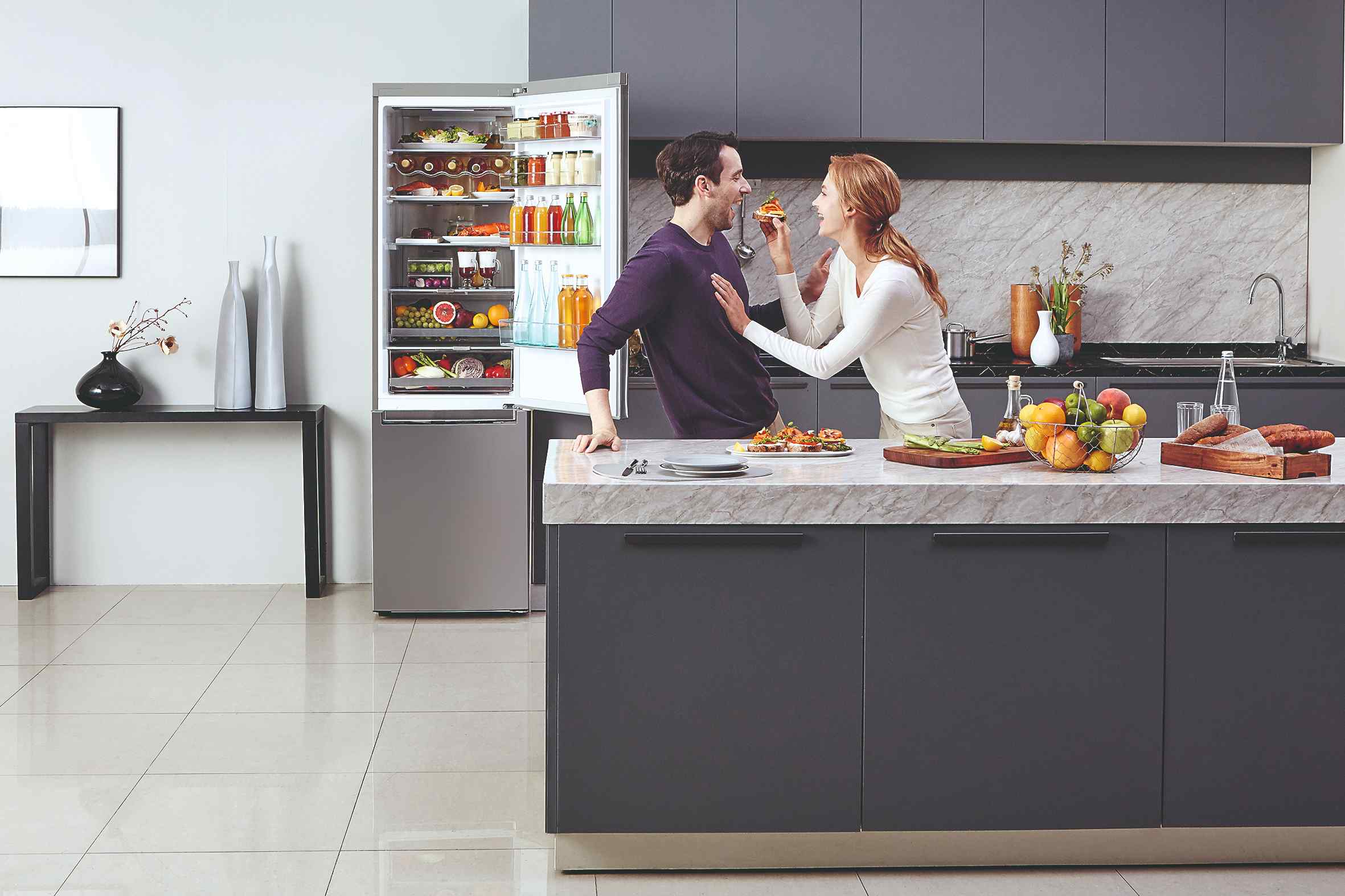 Muž a žena v kuchyni pri otvorenej chladničke
