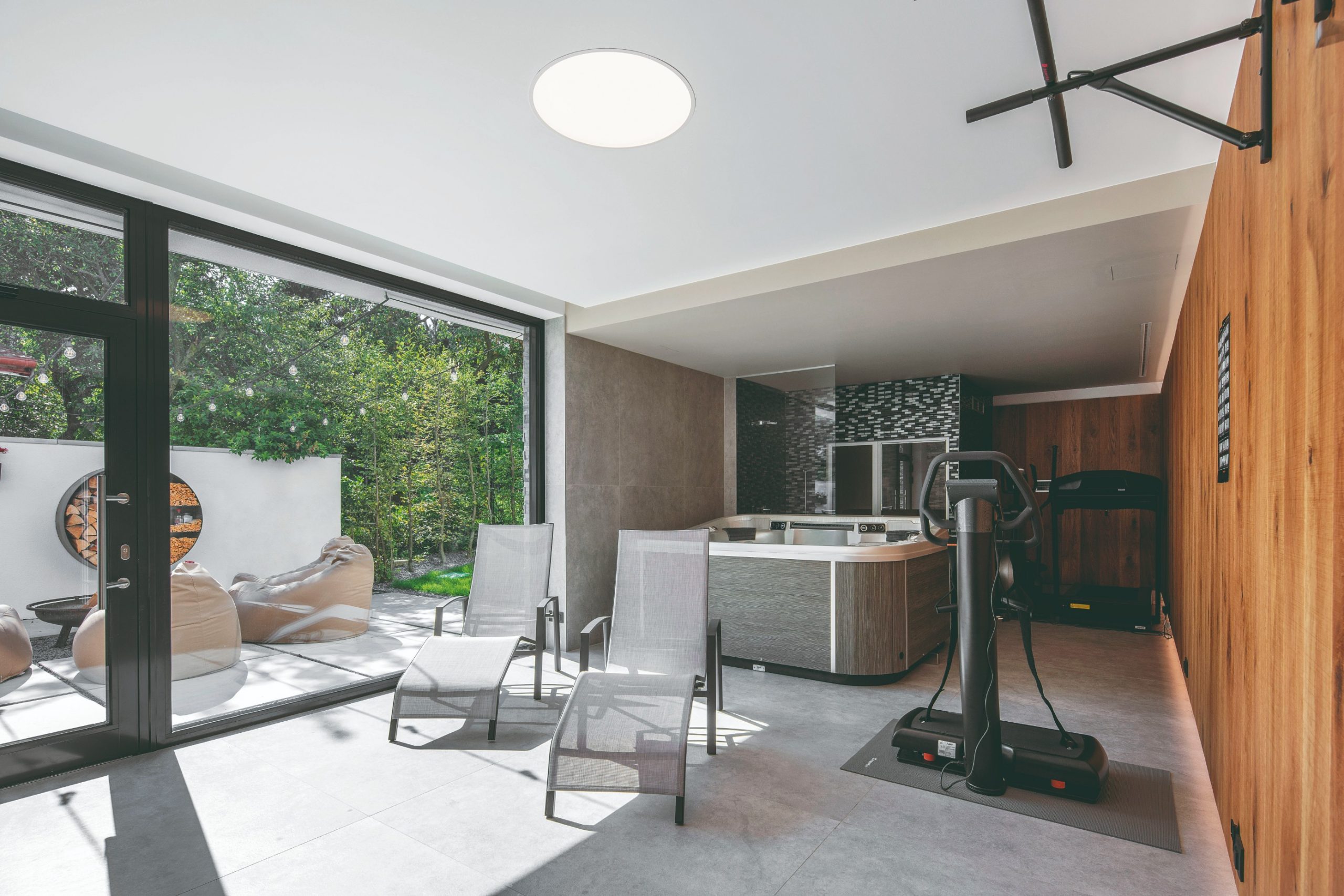 Na juhovýchodnej strane vily sa v suteréne nachádza domáce wellness s vírivkou a so saunou. Nadväzuje naň bočná terasa s otvoreným ohniskom, grilom a s malým bazénom, ktorá je vonkajšími schodmi spojená s prednou záhradou.