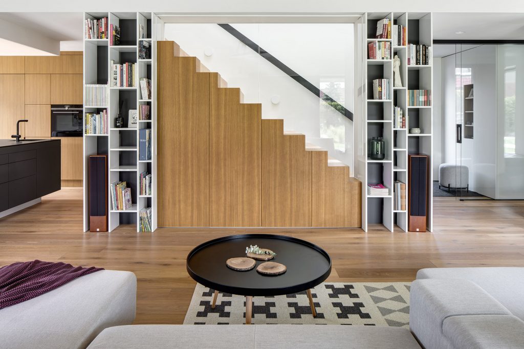 Obývačka s knižnicou a dominantným schodiskom