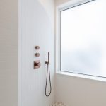 Medená batéria v bielom sprchovom kúte