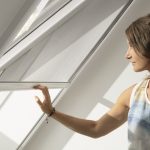 Žena zaťahuje tienenie na strešnom okne