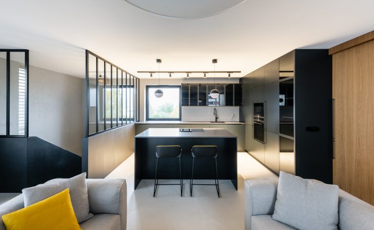 Obývačka s čiernou kuchyňou sklenená stena