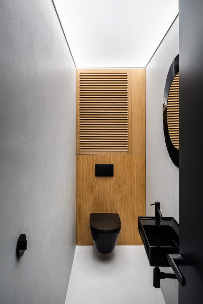 Sivočierna toaleta s drevenou stenou