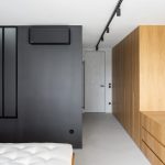 Sivá spálňa s čiernou a drevom