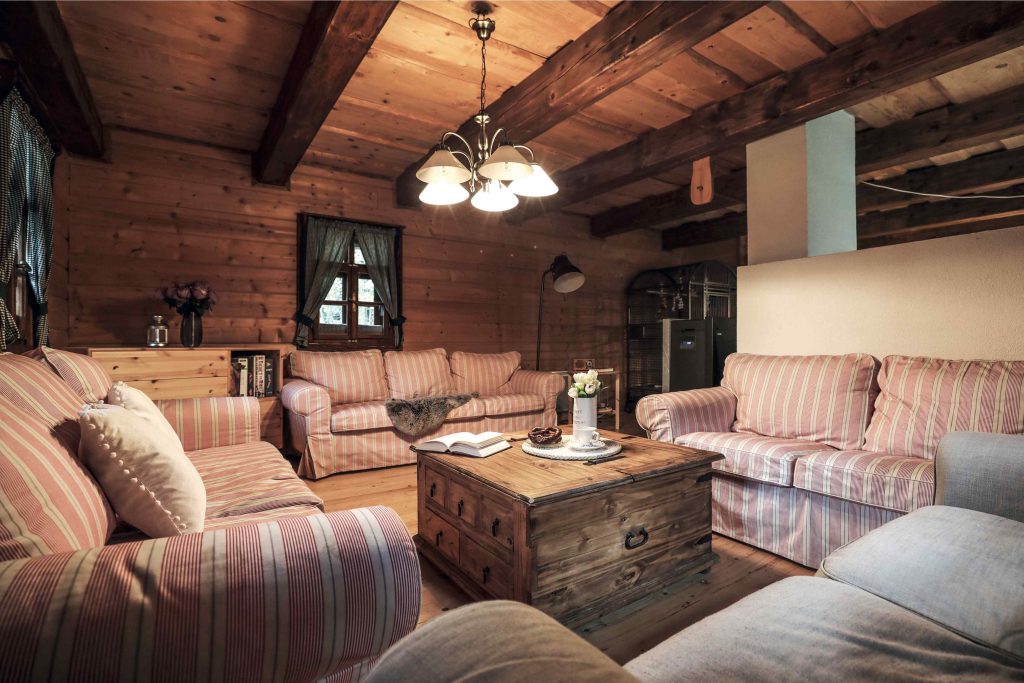 Obývačka v chate s veľkými vzorovanými pohovkami
