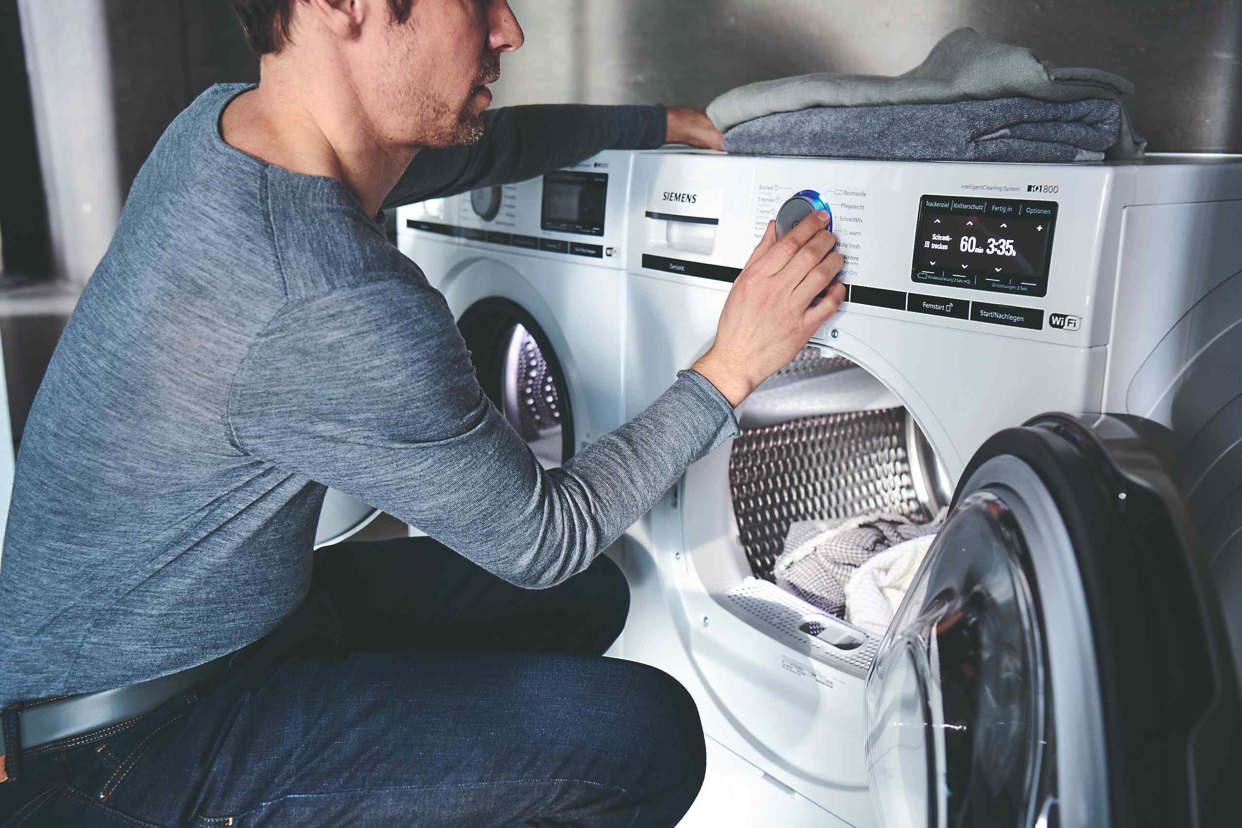 Muž nastavuje sušičku prádla 