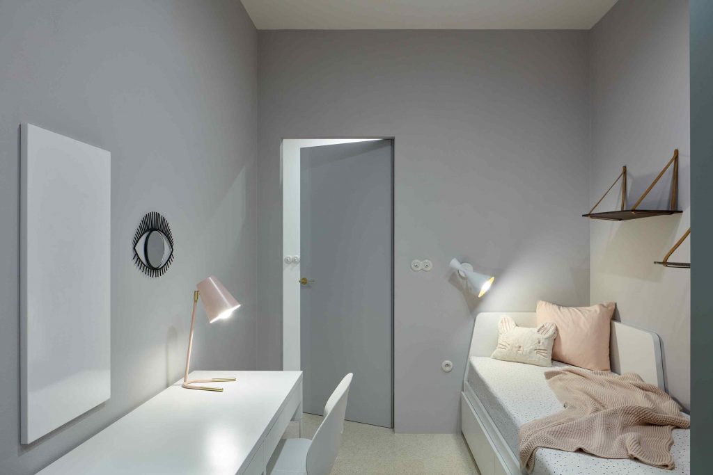 Pastelová izba so single posteľou a stolíkom