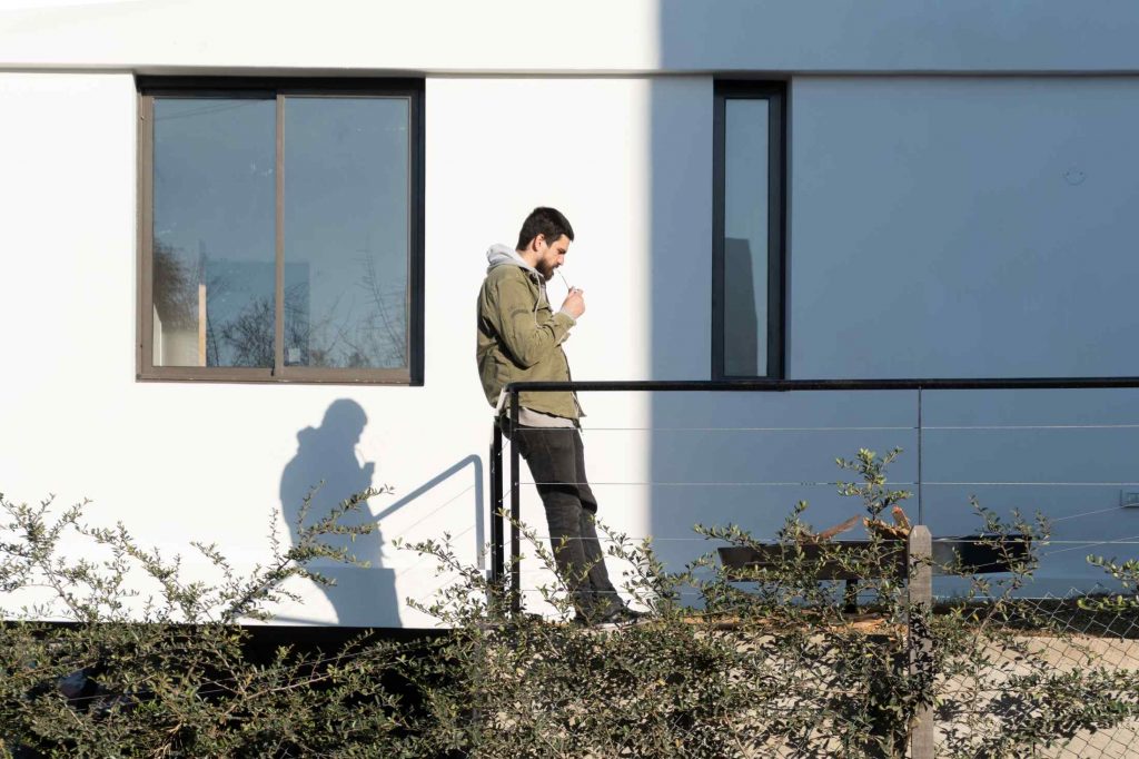 Muž stojí na terase domu
