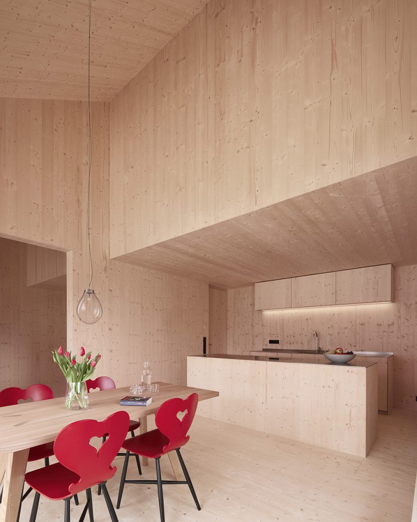 Smreková kuchyňa s jedálňou a červenými stoličkami