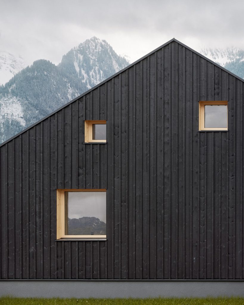 Robustná čierna fasáda s nepravidelnými oknami