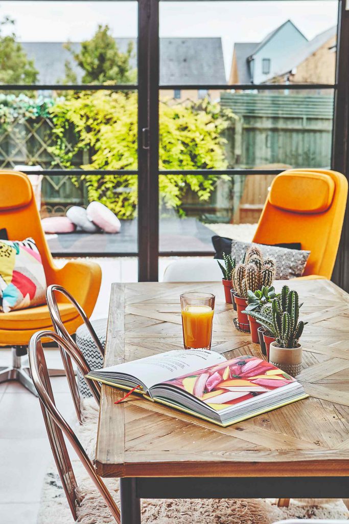 Jedálenský stôl s kaktusmi a oranžové kreslá