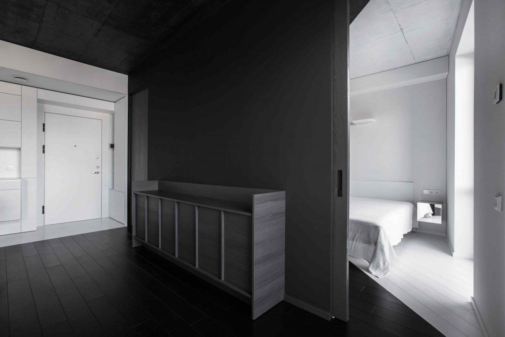 Čierna obývacia časť s bielym precdelom do spálne