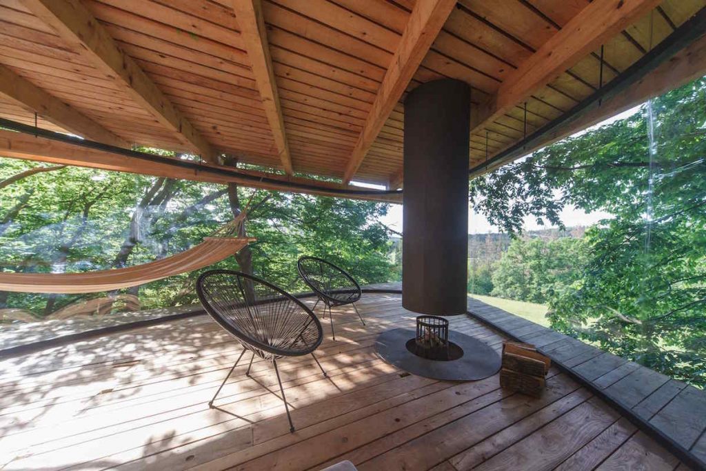 Interiér stromodomu s ohniskom a dizajnovými stoličkami